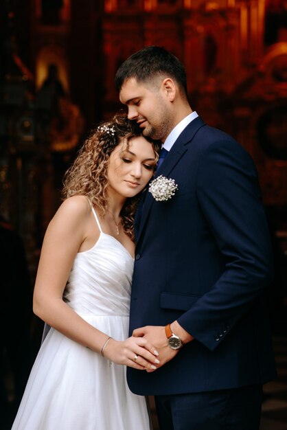 a man and a woman are standing together in front of a wall