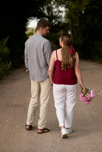 a man and a woman couple. lovers. a guy and a girl are walking. girl with flowers