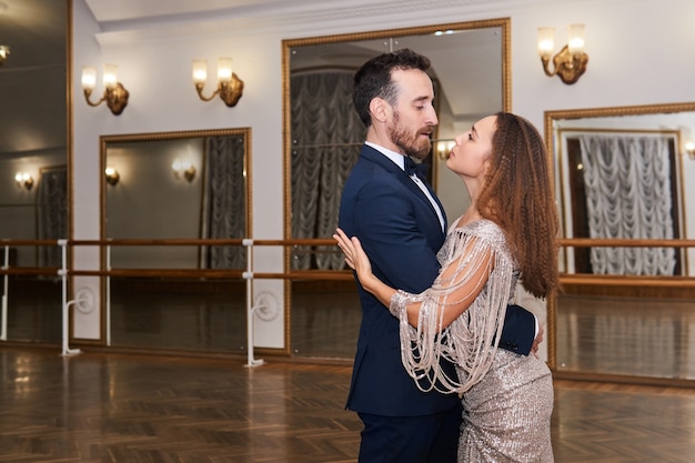 Man and woman dancing classical partner dance in empty ballhall