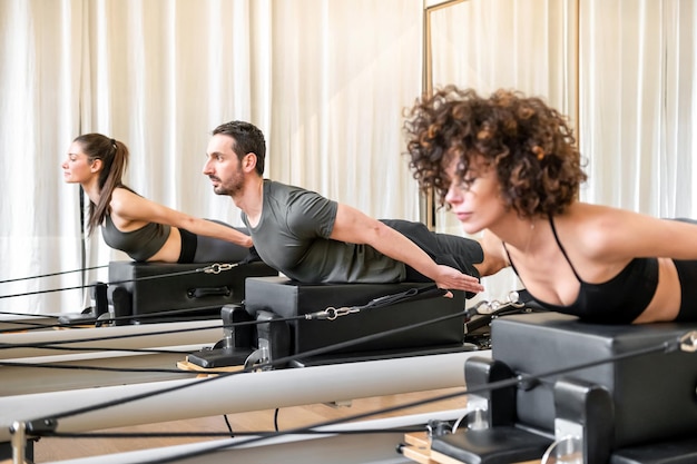 Man and woman doing exercise on pilates reformer