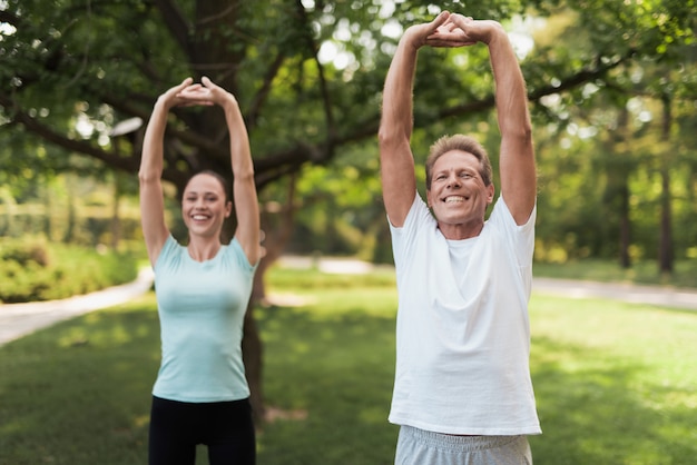 Man and woman doing exercises in the park.