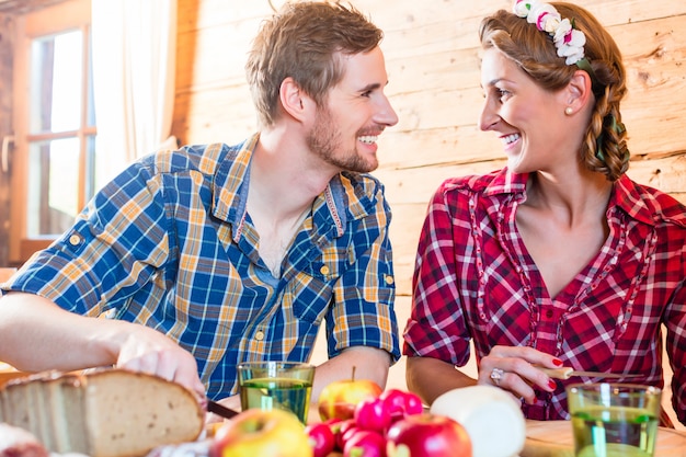 Man and woman eating food in mountain cabin