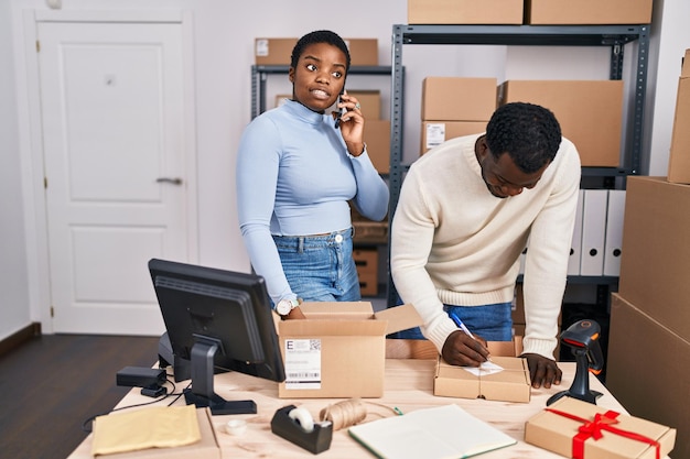 Man and woman ecommerce business workers talking on the smartphone at office