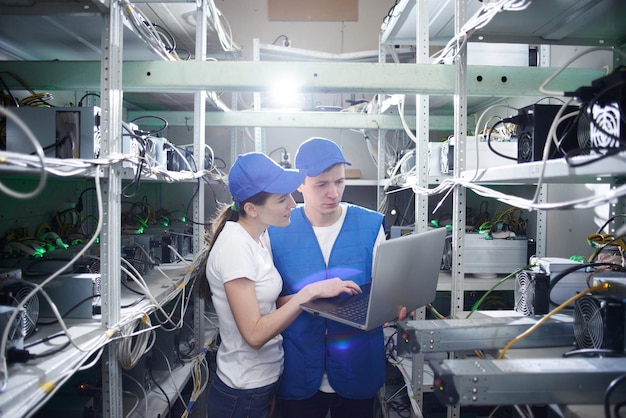 Man and woman on the farm for the extraction of crypto currencies. Bitcoin mining