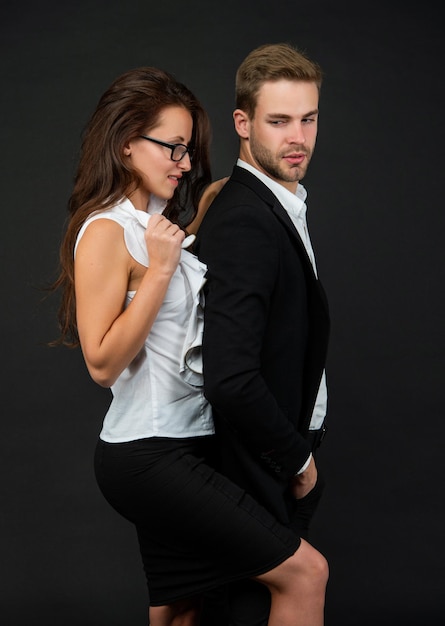 Man and woman in glasses business partners on black background formal couple in love businessman and businesswoman partnership of businesspeople boss and employee passionate colleague experts