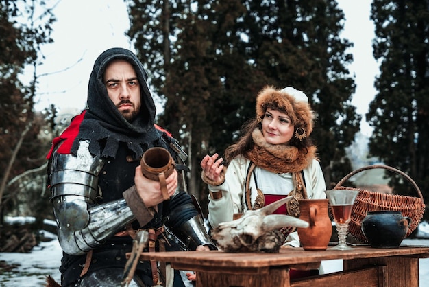 A man and a woman in historical costumes are sitting at a table