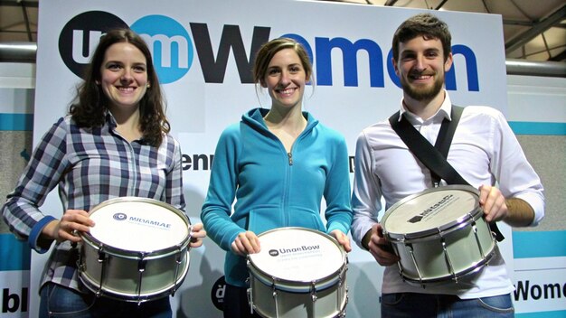 Photo a man and woman holding drums with the word quot w quot on the back of them