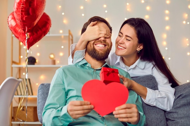 Photo a man and woman holding a heart shaped box that says love