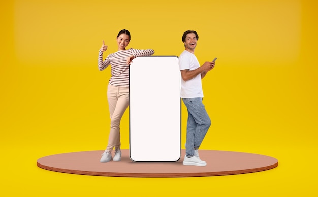 Man and woman leaning at big smartphone with blank white screen