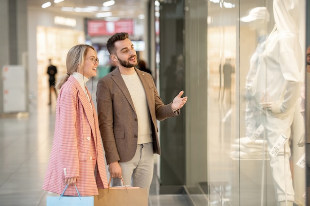 A man and a woman looking at mannequin in a display in a store