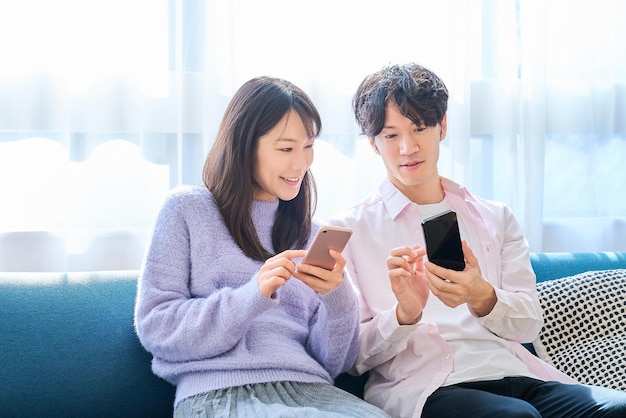 A man and a woman looking at smartphones