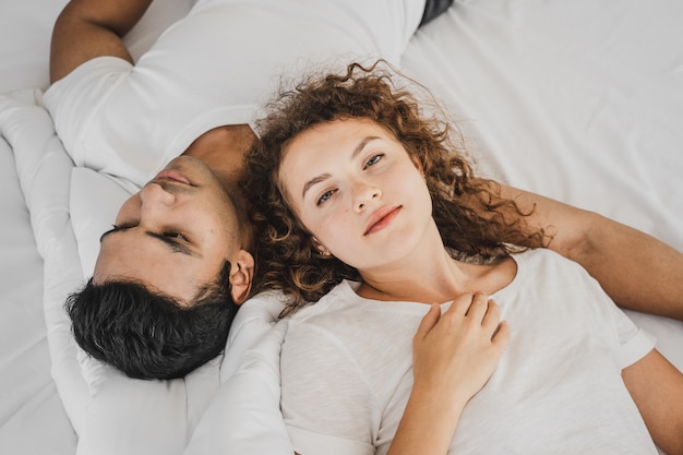 A man and a woman lying on a bed