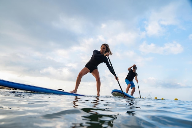 Man and woman paddlesurfing in spain