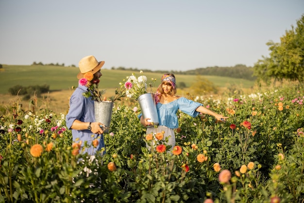 Man and woman pick up flowers at farm outdoors