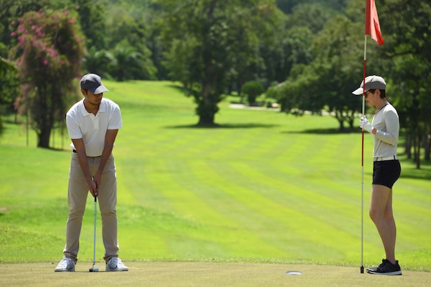 Man and woman playing golf on a beautiful natural golf course