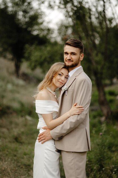 a man and woman pose for a photo in the woods