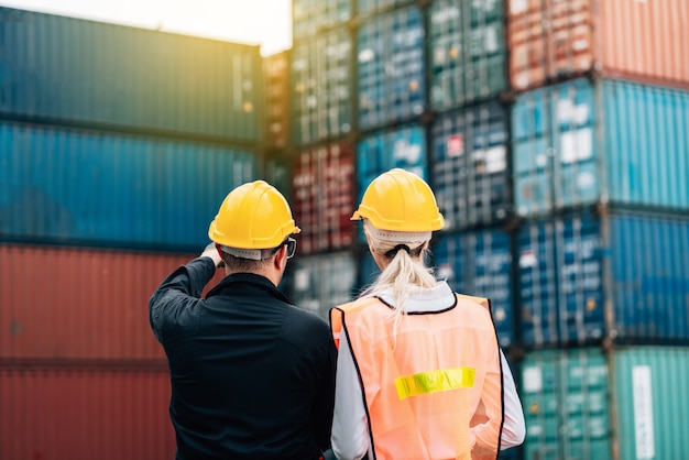 man and woman in safety jumpsuit workwear with yellow hardhat