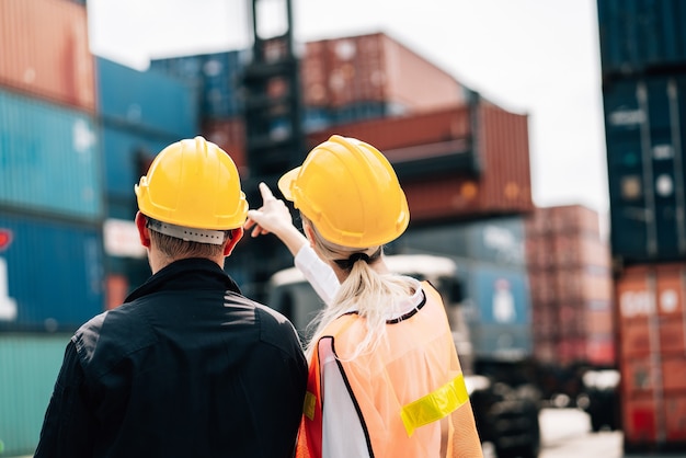 man and woman in safety jumpsuit workwear with yellow hardhat