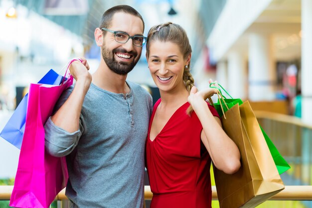 Man and woman in shopping mall with bags