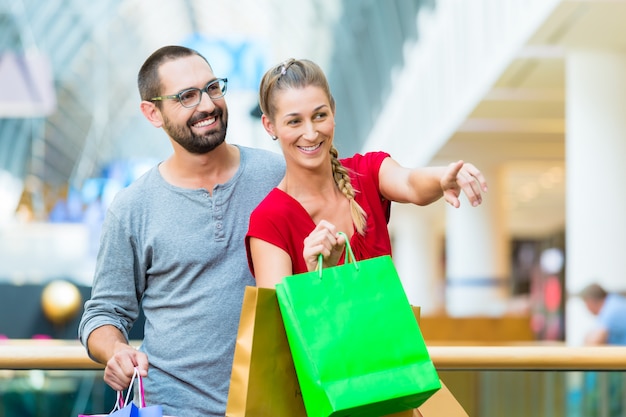 Man and woman in shopping mall with bags