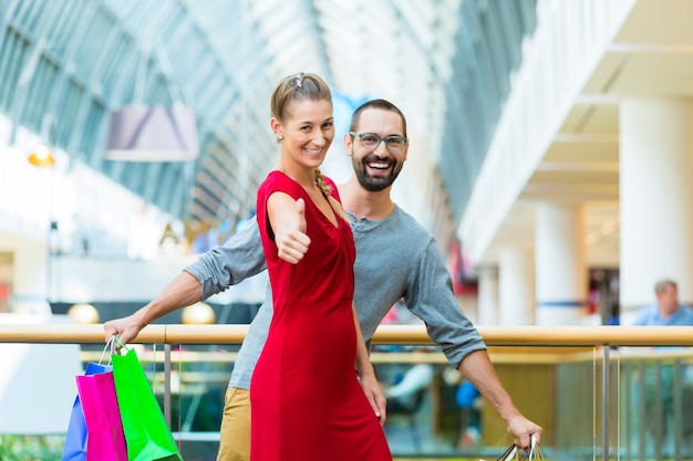 Man and woman in shopping mall with bags