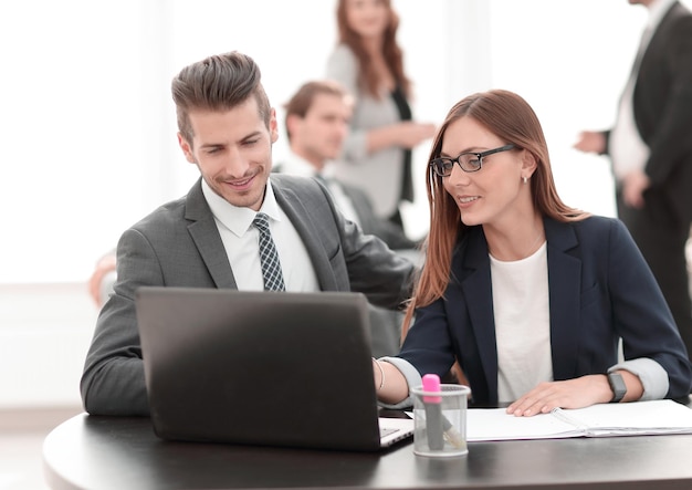 Man and woman sitting at table in coworking office