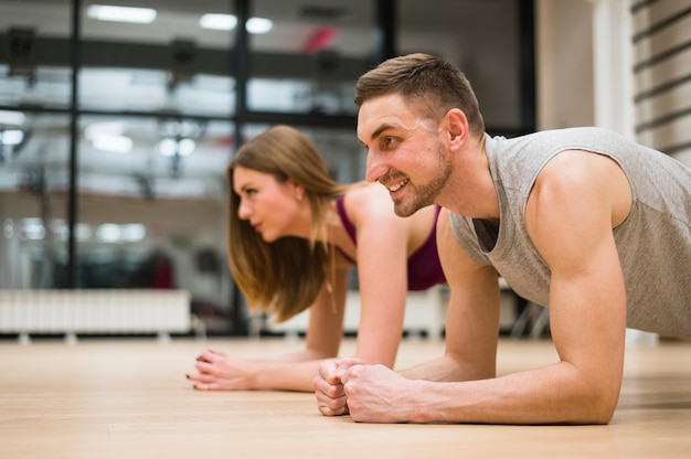 Man and woman stretching at the gym