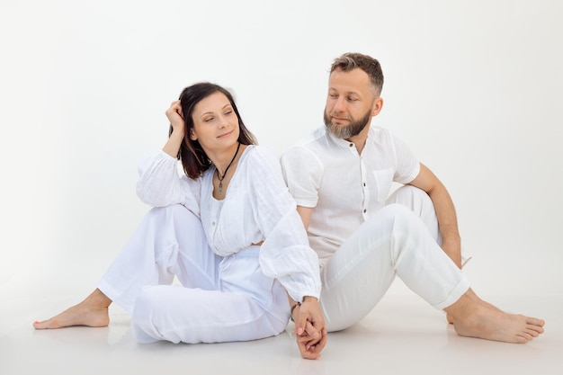 Man and woman on studio shot couple in white outfit holding hands together psychology treatment for