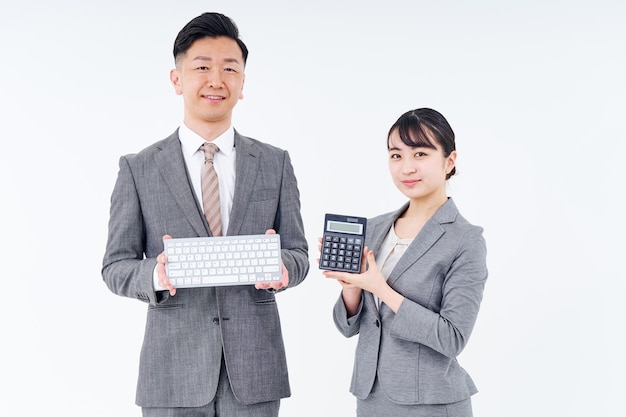 Man and woman in suits with keyboards and calculators