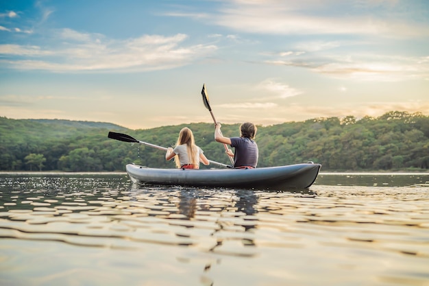 Man and woman swims on kayak in the sea on background of island Kayaking conceptKayaking concept with family of father mother at sea