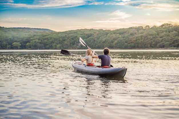 Man and woman swims on kayak in the sea on background of island kayaking conceptkayaking concept