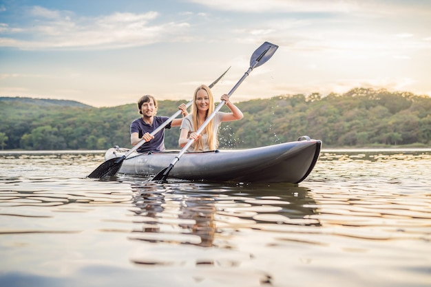 Man and woman swims on kayak in the sea on background of island kayaking conceptkayaking concept