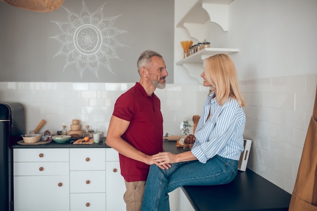 Man and woman talking in the kitchen and looking involved