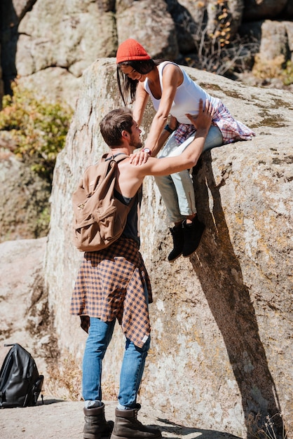 Man and woman teamwork climbing or hiking in summer