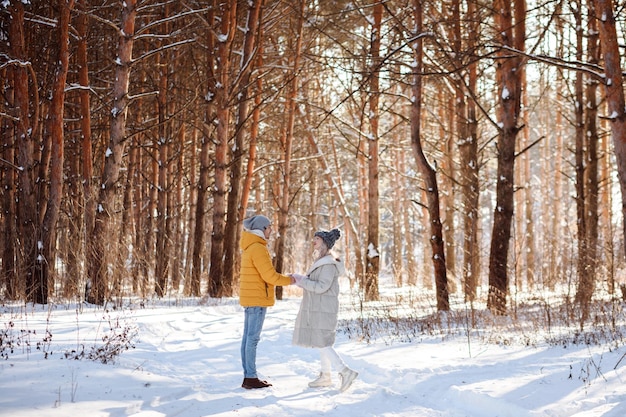 Man and woman in warm clothes in winter forest outdoors