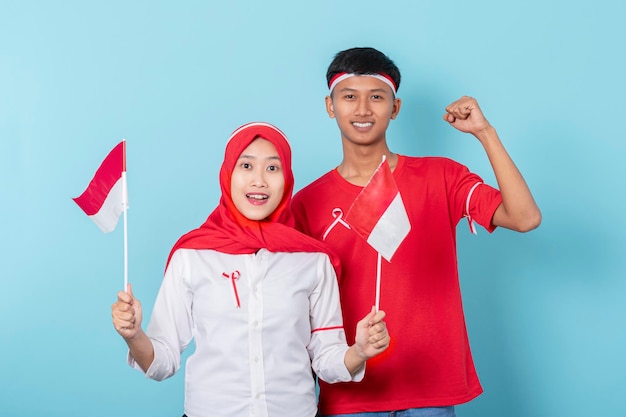 Man and woman wearing full red and white attributes excited to celebrate indonesia independence day