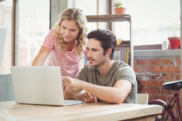 Man and woman working on laptop in office