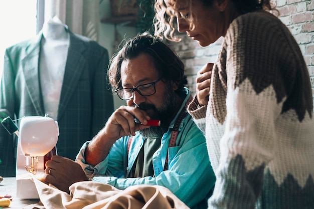 Man and woman working together as a team in garment tailor production Artisan freelance job activity concept Couple tailoring and working at home or workshop Job occupation people concentration