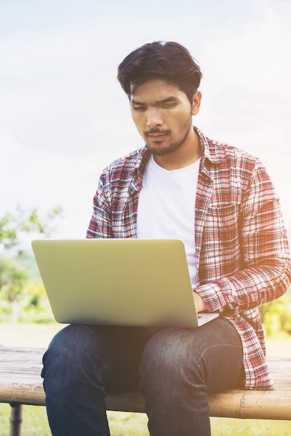 Man working on laptop. Nature background.