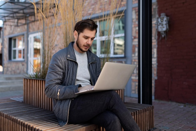 Man working on laptop outside online