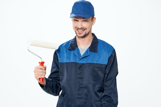 A man in a working uniform painting the walls repairing the house