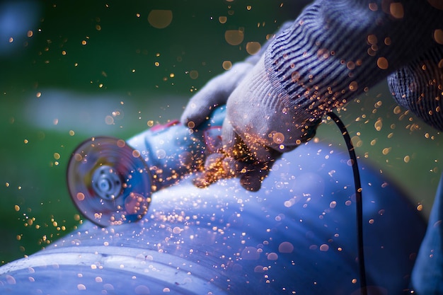 Man working with grinder saw close up view on tool Electric saw and hands of worker with sparks Worker cutting metal with grinder