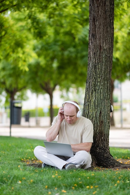 A man works on a laptop in the park