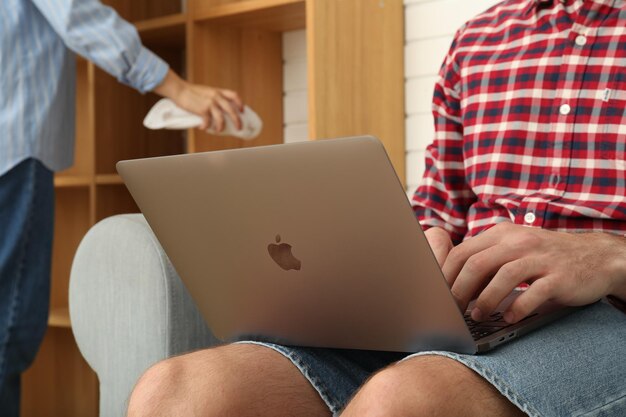 A man works on a laptop on a sofa