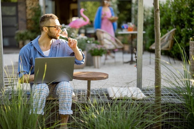 Man works on laptop while sitting at backyard