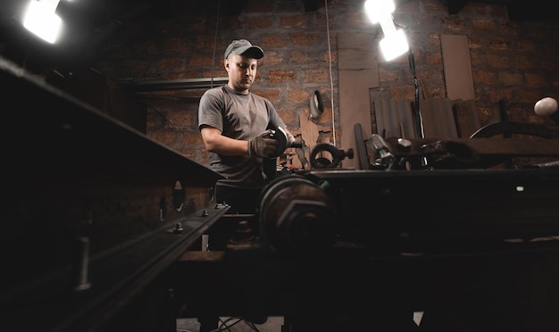 A man works with an angle grinder in his home workshop Making metal products with your own hands