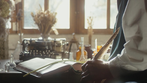 A man writer dips his pen into an inkwell and prepares to write a book in his workshop premium photo