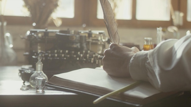 A man writer dips his pen into an inkwell and prepares to write a book in his workshop premium photo