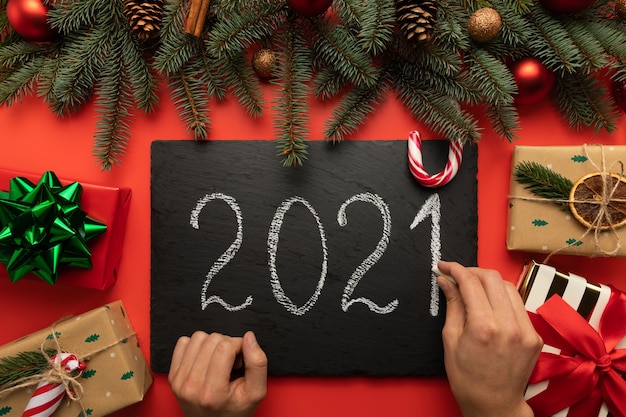 A man writes the inscription  on a black chalkboard