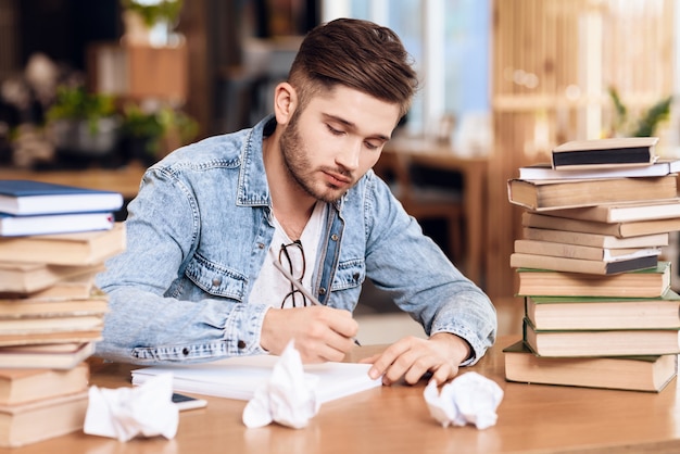 A man writes something on a piece of paper around him.